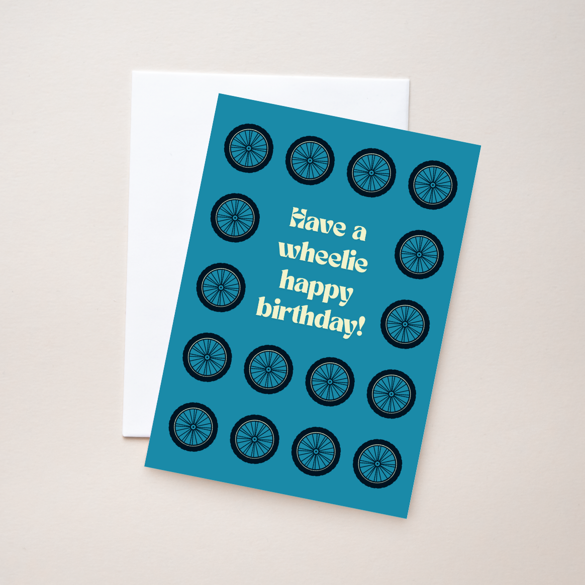 Blue birthday card with bicycle wheel design and text on a beige background.