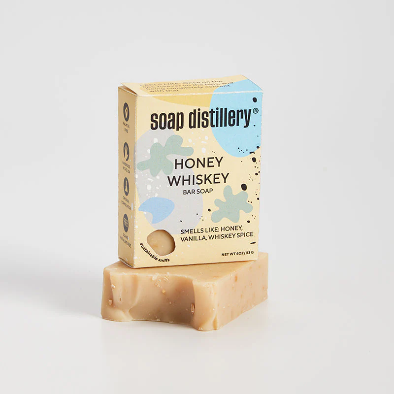 Bar of soap with Soap Distillery packaging on a light gray background.