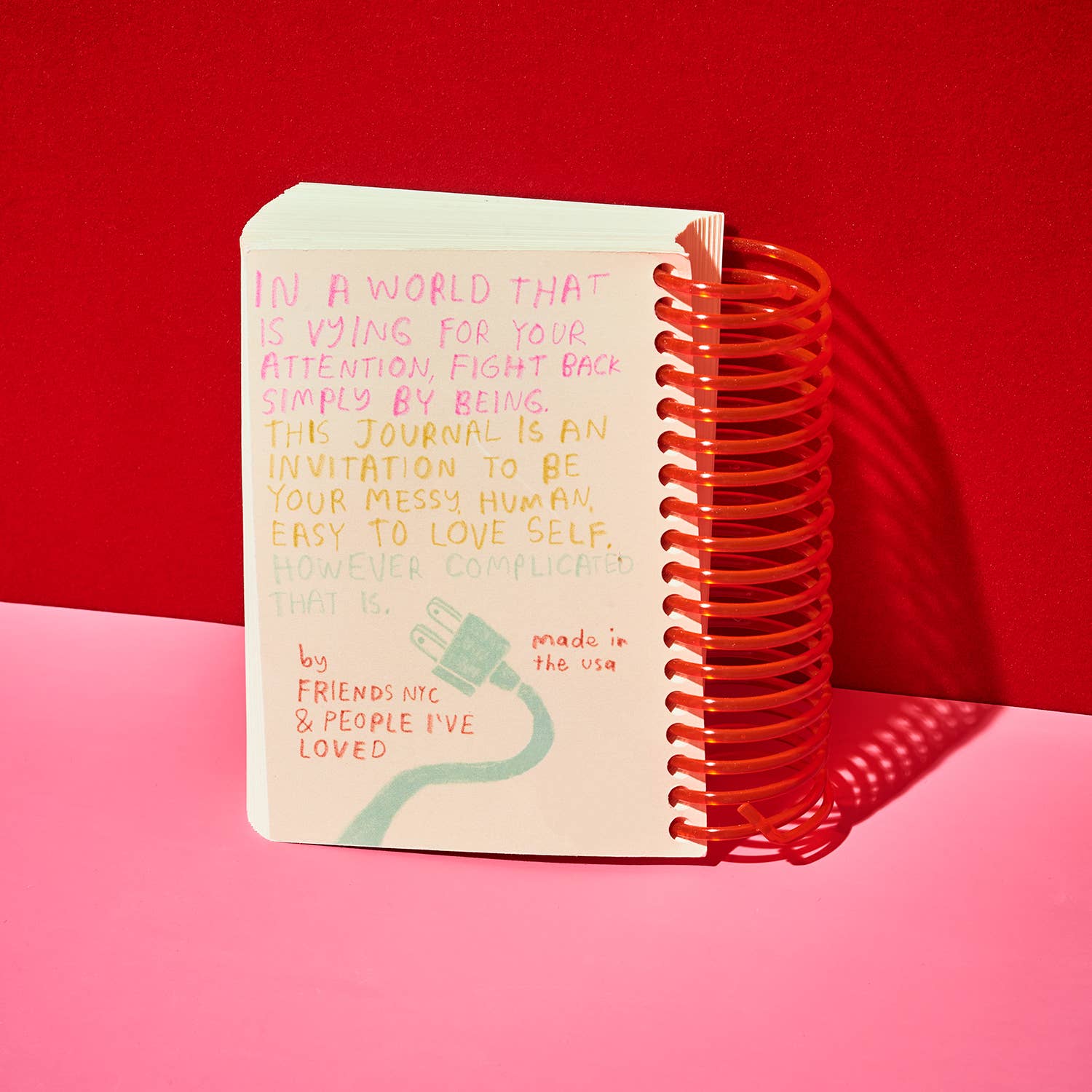 Journal with text on a red and pink background.