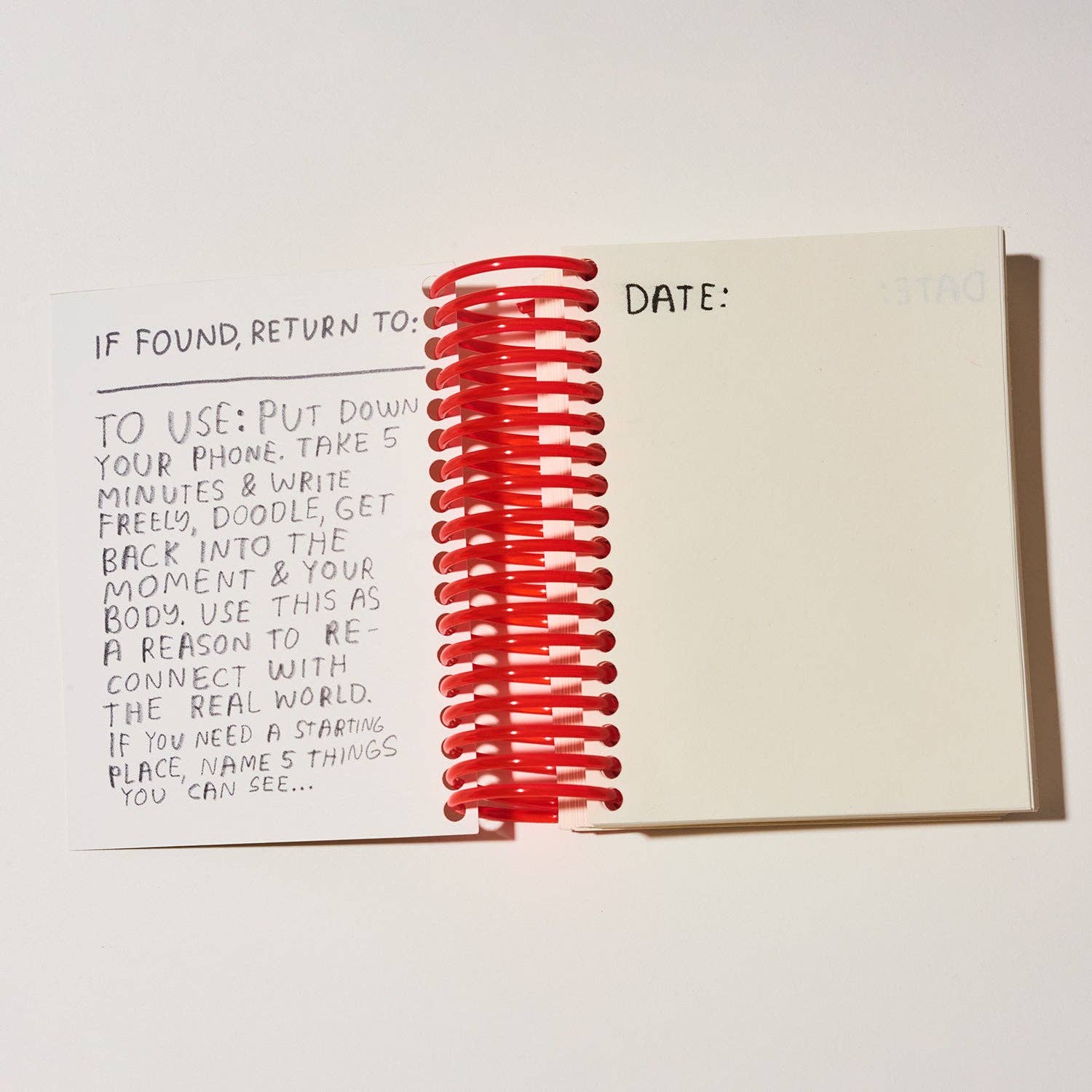 Notebook with a red spiral on a white background.