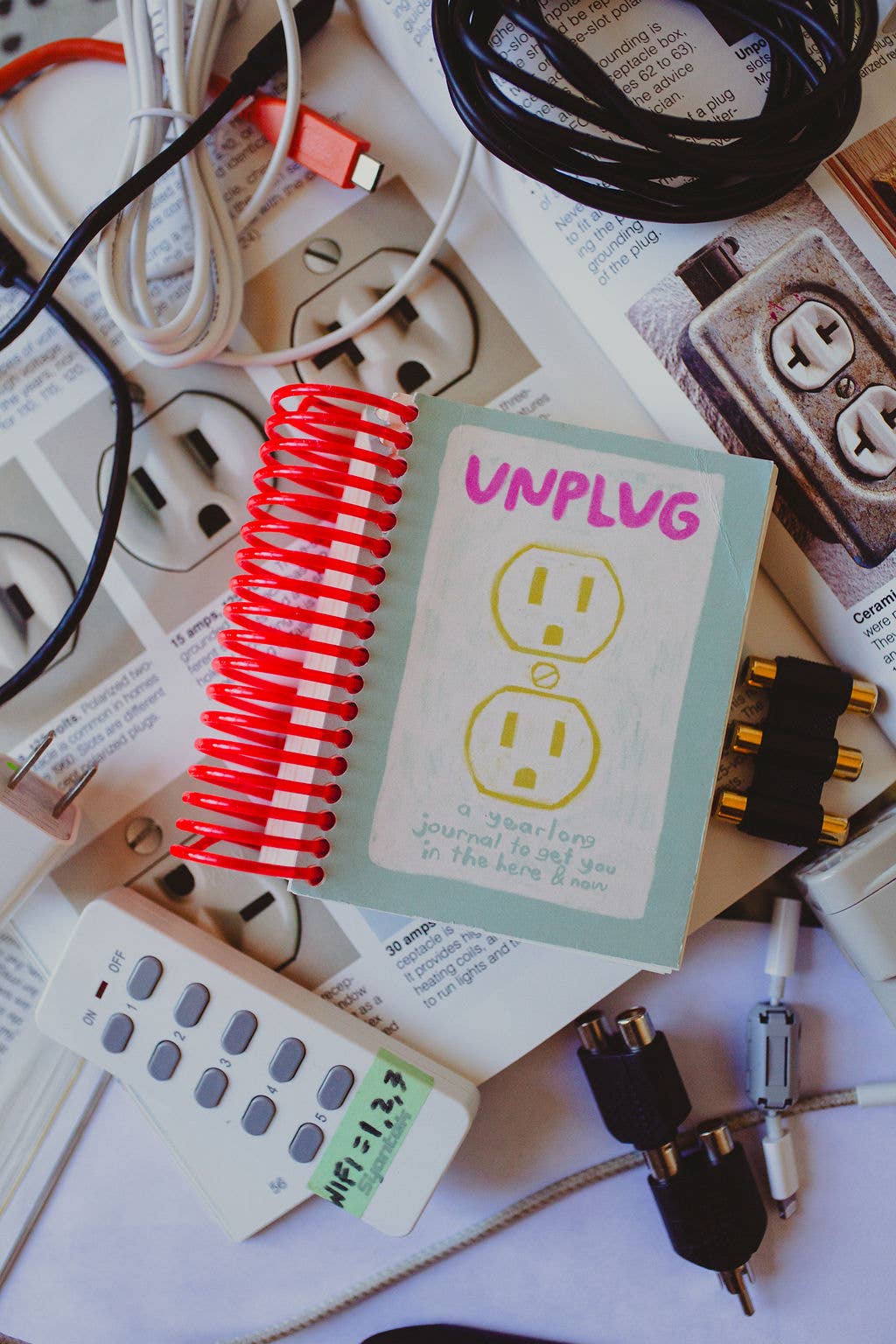 Card with 'UNPLUG' text surrounded by electrical cords and plugs on a white background.